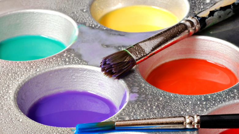 Mini muffin tin filled with different colors of paints