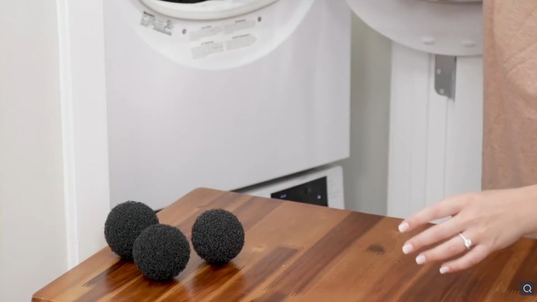 Joie Washer Balls on a wooden table in a laundry room