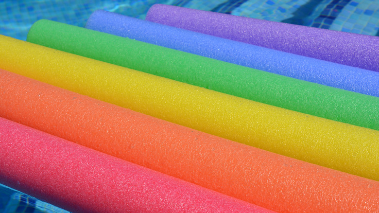 Colorful pool noodles floating in the pool.