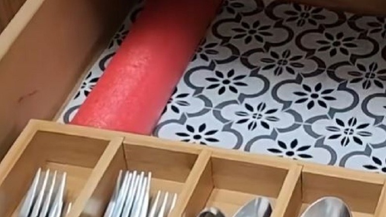 Pool noodle inside kitchen drawer to stop shuffling silverware.