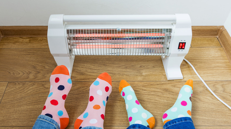 Feet being warmed in front of a space heater
