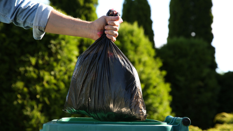 Man throwing trash into a bin