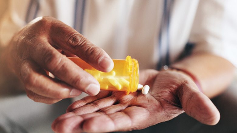 Person placing pills in their hand