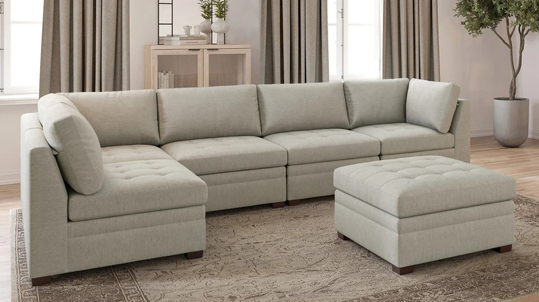 A large light beige sectional sofa sits in a neutral living room