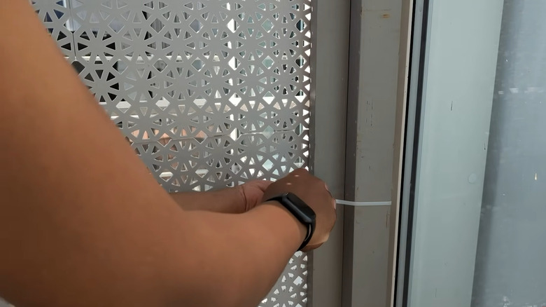 Hands attaching Ikea flooring screen to support