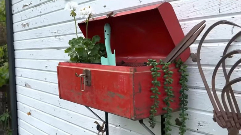 Toolbox mounted on wall outdoors to store plants and garden tools