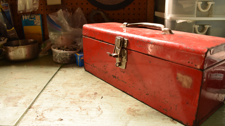 Vintage red metal toolbox on workshop table