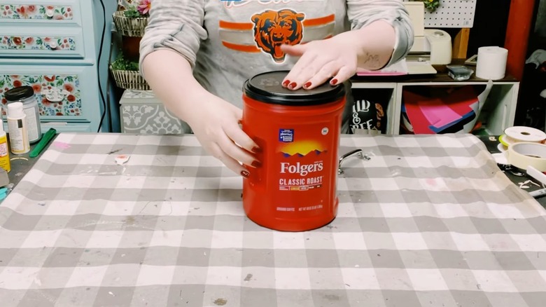 Woman with empty Folger's coffee canister for home DIY project