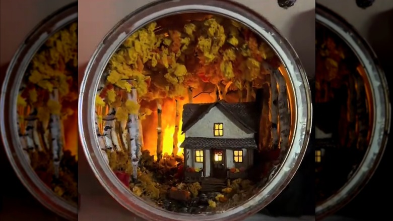 Artistic diorama with trees and house nestled inside upcycled coffee tin