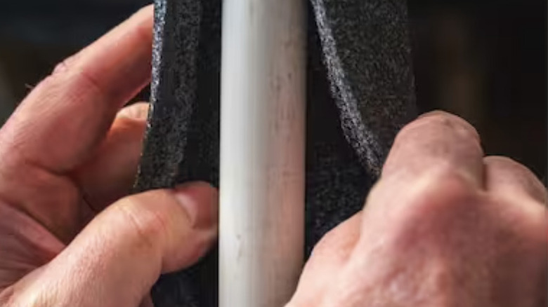 Person overlaying pipes with insulation