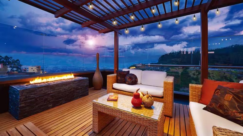 A strand of Edison bulb string lights hangs over a modern glass-enclosed patio overlooking a night sky