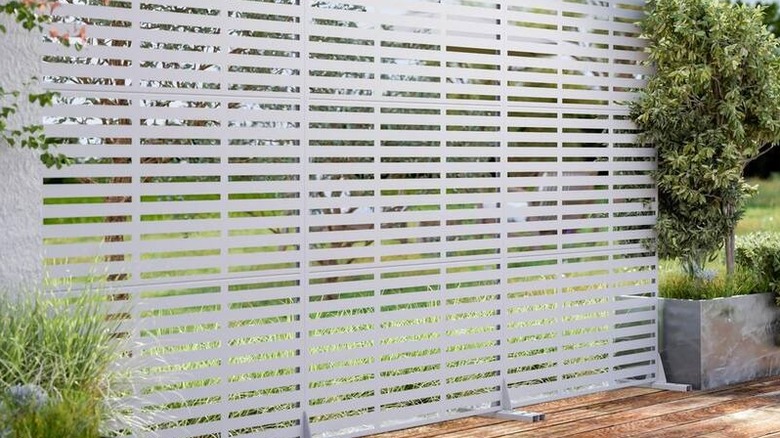 A Dovelina Adams metal garden privacy screen set up outside