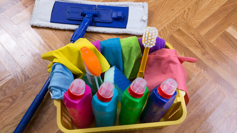 Basket full of cleaning products next to dry mopper