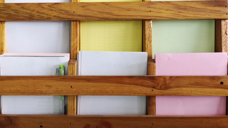 A wooden paper holder mounted to the wall