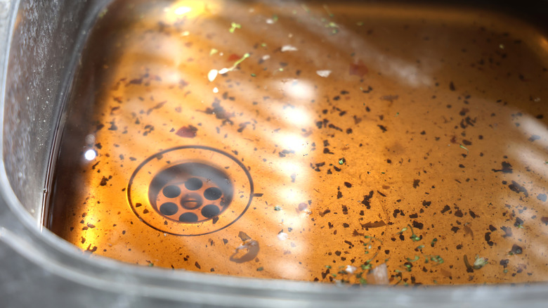 kitchen drain and sink filling with brown liquid.