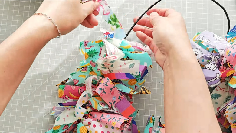 hands arranging ribbon on wire.