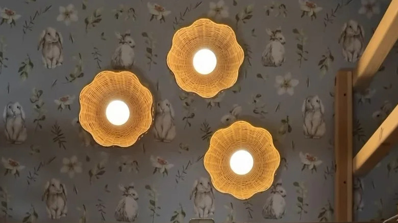 Trio of flower-like DIY wicker basket lights on wall with floral springtime wallpaper
