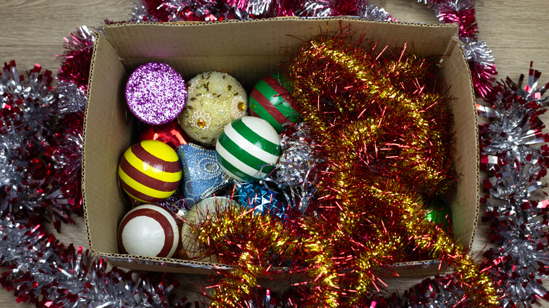 Cardboard box full of tinsel and Christmas ornaments