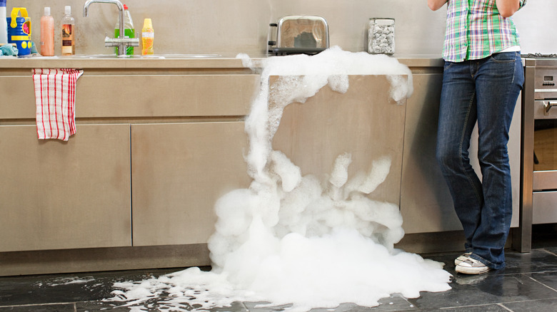 Soapy water overflowing out of a built-in dishwasher