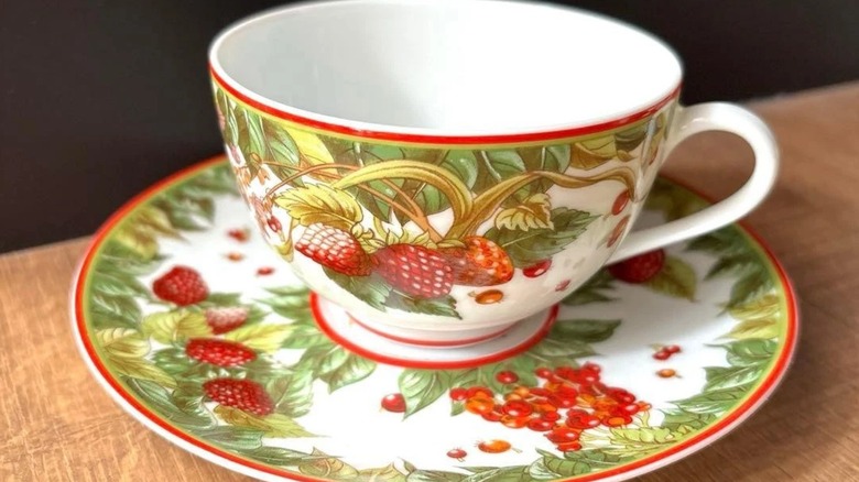 A teacup and saucer with Hermes Le Jardin de Pythagore pattern