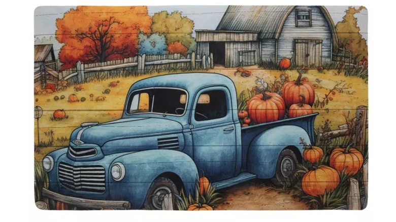 A decorative fall doormat is shown in a detail shot