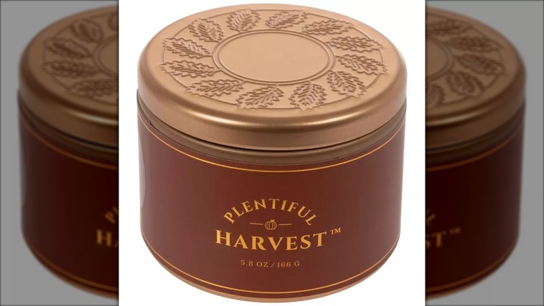 A Plentiful Harvest Scented Candle with decorative leaf lid is shown in a detail shot