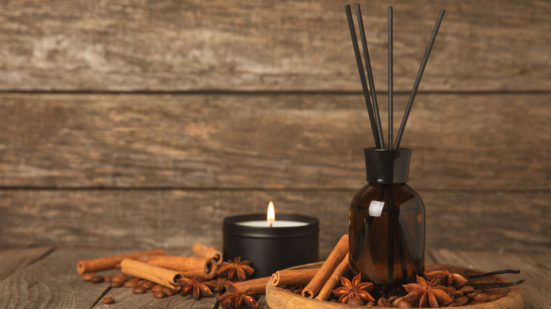 Reed diffuser in amber glass on tray with cinnamon sticks