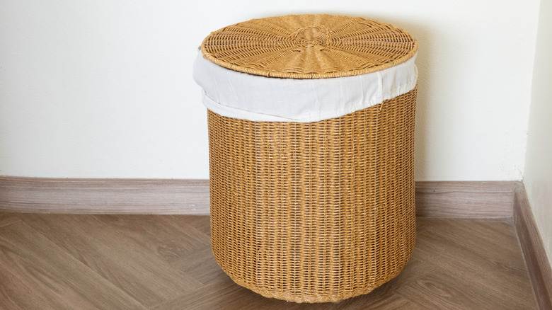 Large wicker laundry hamper with a lid sitting on the floor