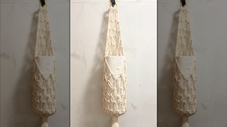 Macrame toilet paper holder hanging from hook
