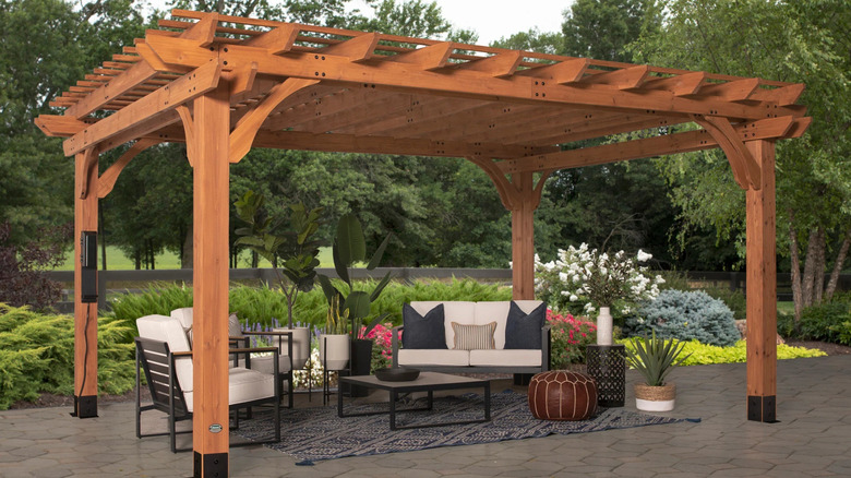 Beaumont wood freestanding pergola on a patio area with a seating arrangement underneath