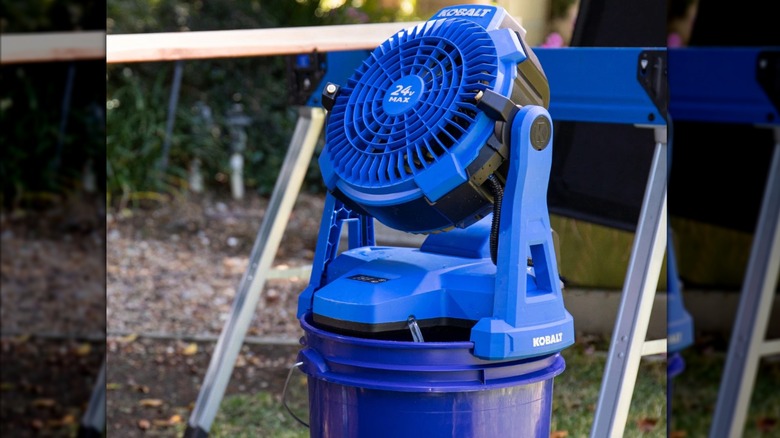 Blue Kobalt misting fan sitting on a Lowe's bucket on the ground