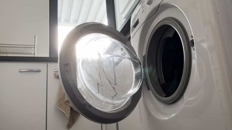 Empty washing machine with door ajar
