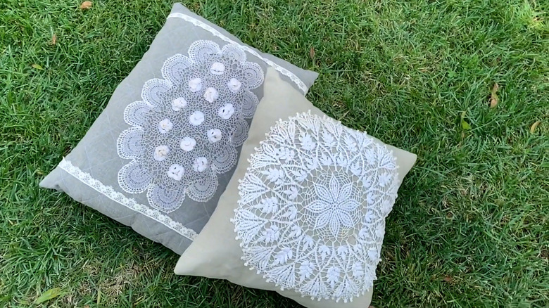 Decorative throw pillows with sewed doilies in outdoor grass