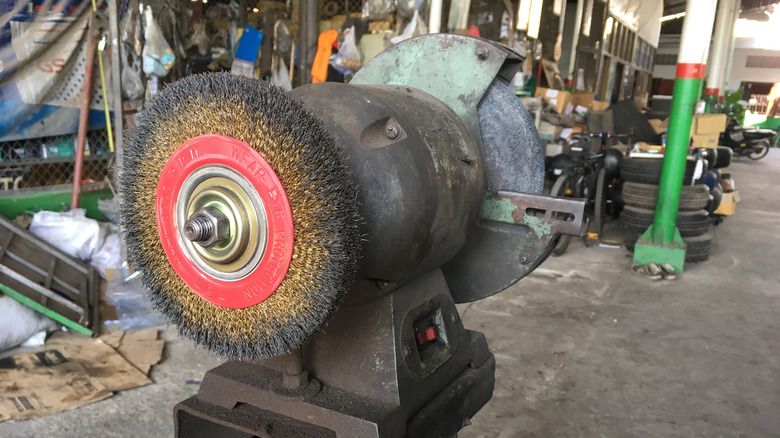 A brass wire wheel mounted to a bench grinder