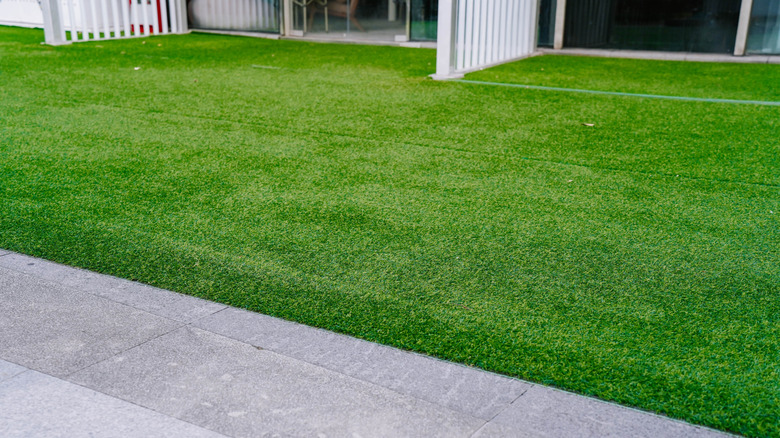 Artificial grass, or turf, outside of homes next to a cement sidewalk