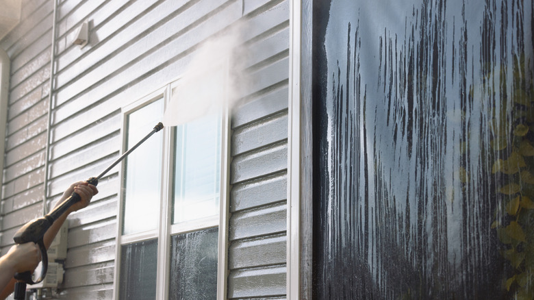 A pressure washer used to clean siding and windows on a house