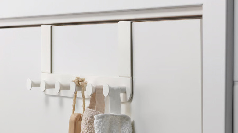 A white ENUDDEN hanger from IKEA hangs on the back of a white door
