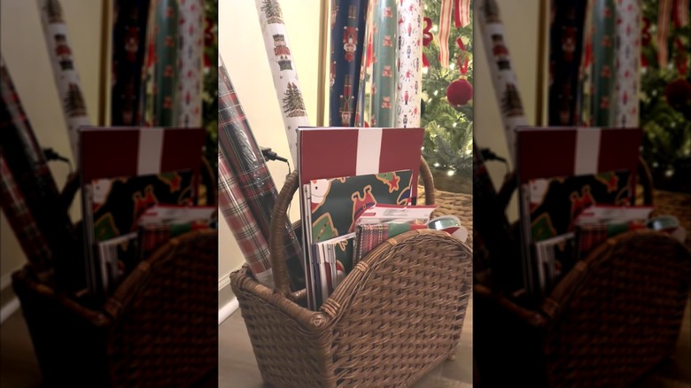Festive holiday wrapping paper and gift boxes tucked into woven magazine basket
