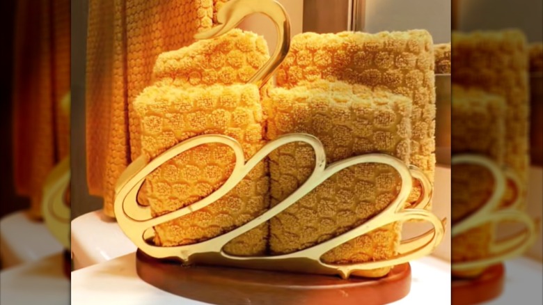 Elegant brass and wooden publication holder with bathroom hand towels