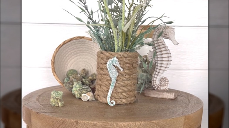 Soup can wrapped in rope and surrounded by coastal, beach-inspired decor on wood table