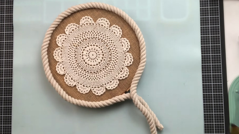 A doily on burlap with a rope border.