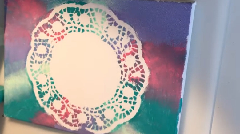 A colorful canvas with a blank doily-shaped center.