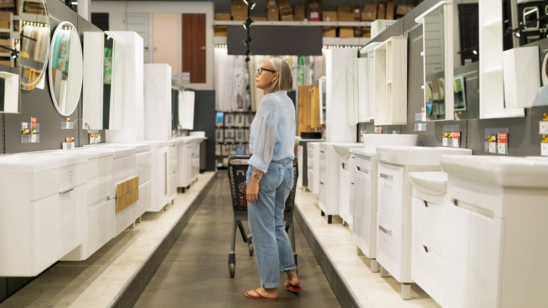 woman shopping in bathroom aisle of home improvement store