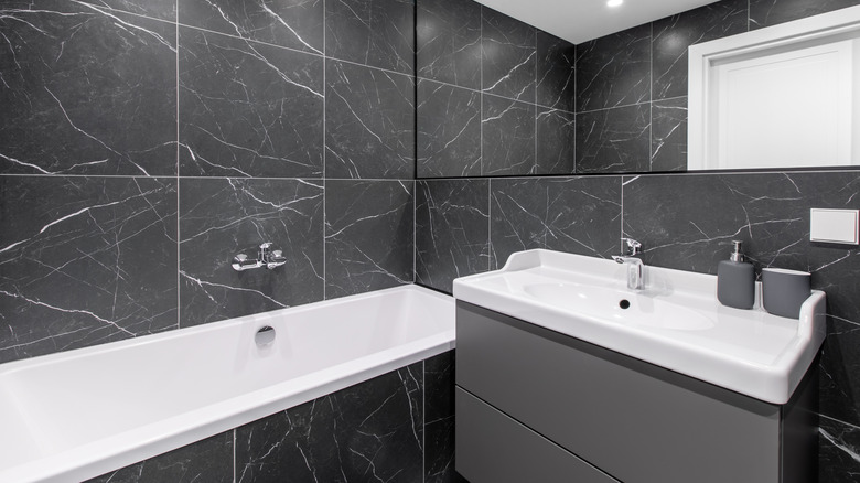 Bathroom with matching gray tiles, cabinets, and accessories