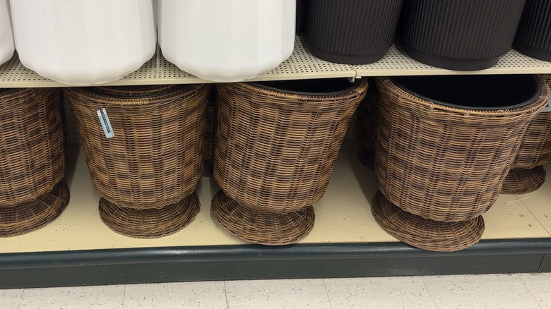 Four brown woven planters sit on the bottom shelf in a Hobby Lobby display