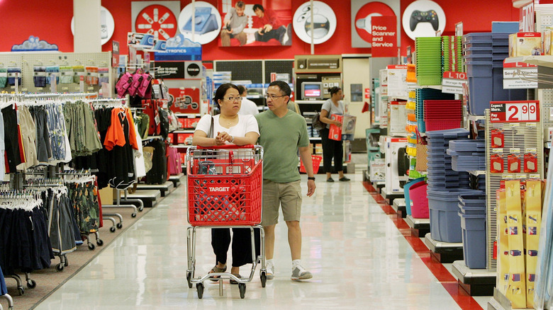 A middle-aged couple pushes a cart through the aisles at Target