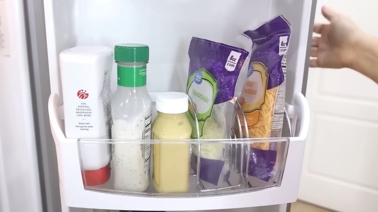 Wire napkin holders holding packaged cheese in refrigerator inside door compartments