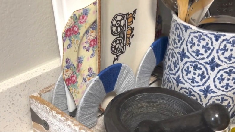 Yarn-wrapped dollar store napkin holders holding various decorative dishes