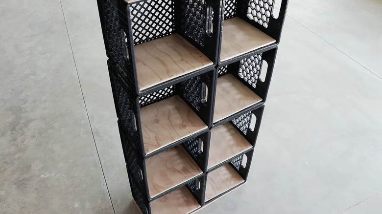 Black milk crate book shelf with wood shelves on industrial floor