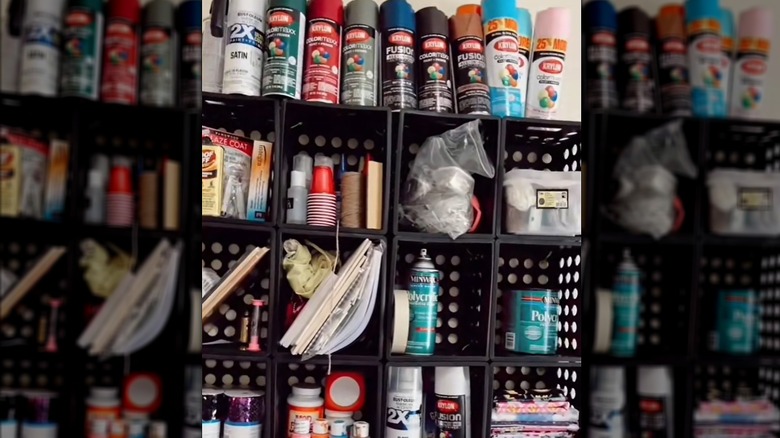 Milk crates assembled into storage shelf with various crafting tools and supplies